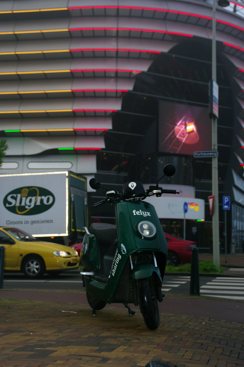 green and black motorcycle parked beside yellow car