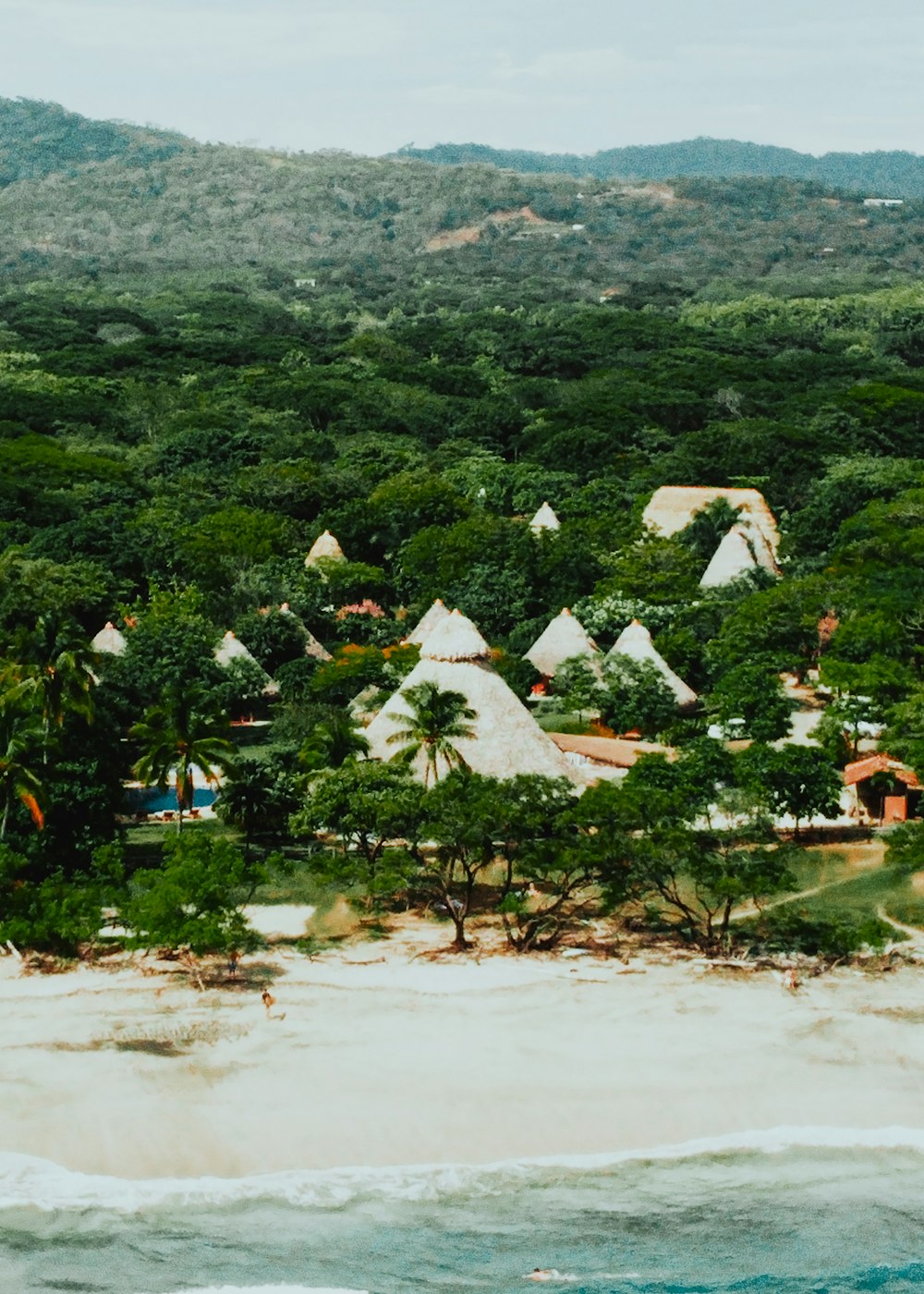 Maisons blanches et brunes sur un champ d’herbe verte pendant la journée