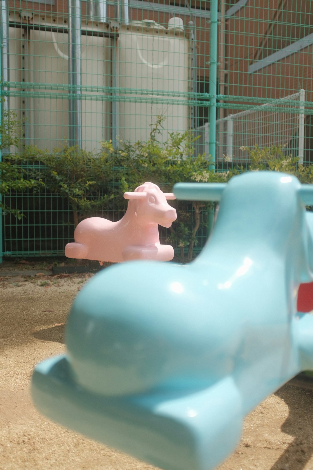 white ceramic horse statue near green metal fence during daytime