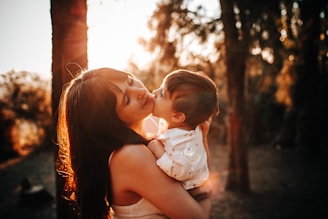 woman in white tank top carrying baby in white dress
