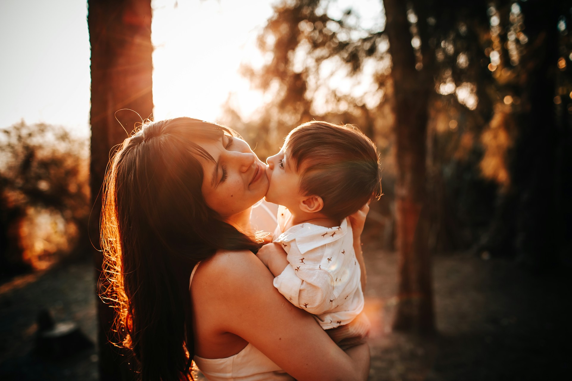 woman in white tank top carrying baby in white dress