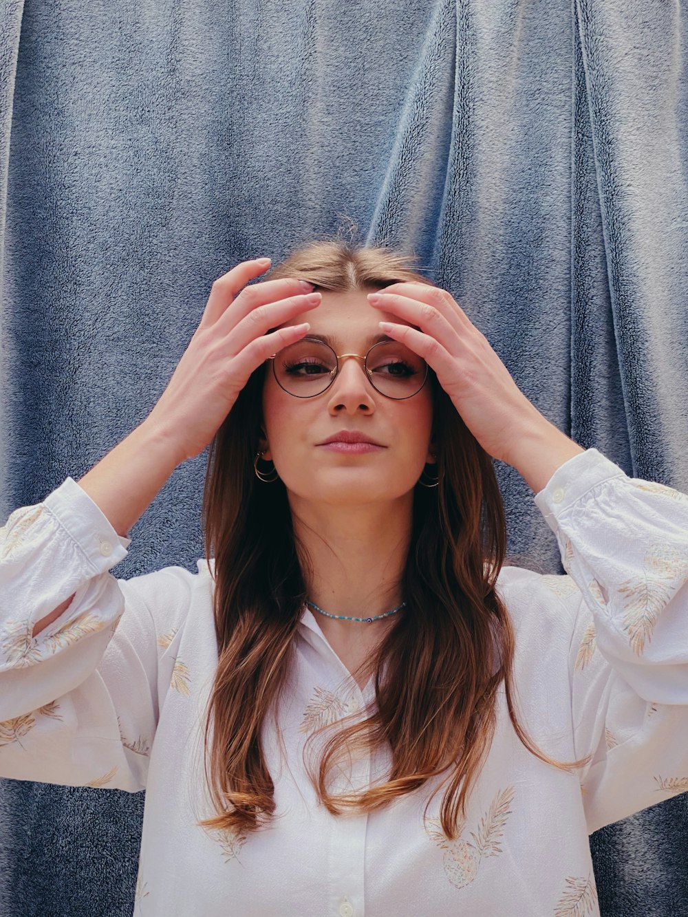 woman in white long sleeve shirt covering her face with her hair