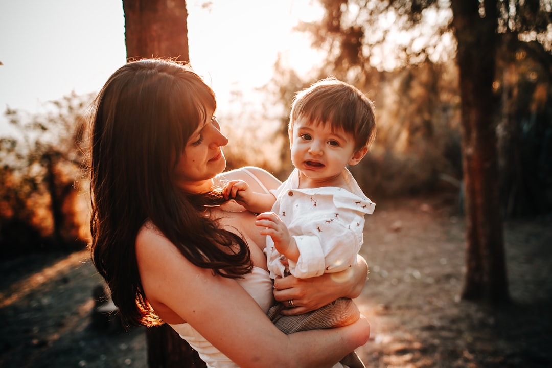 woman in black tank top carrying baby in white shirt