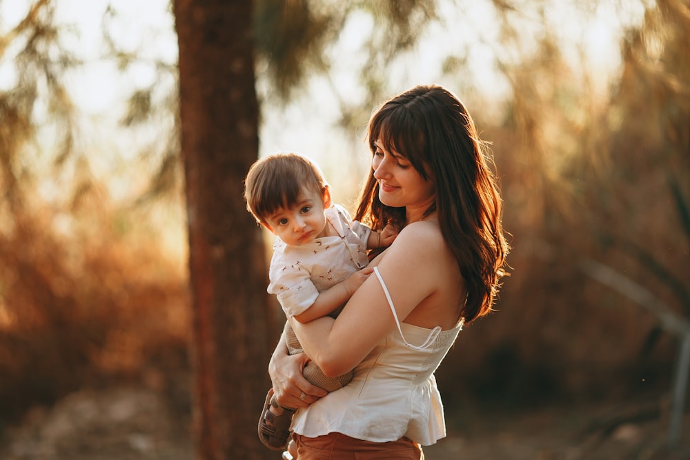 woman in white dress carrying baby in white dress