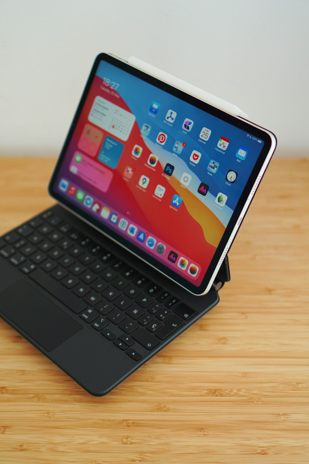 black ipad with keyboard on brown wooden table