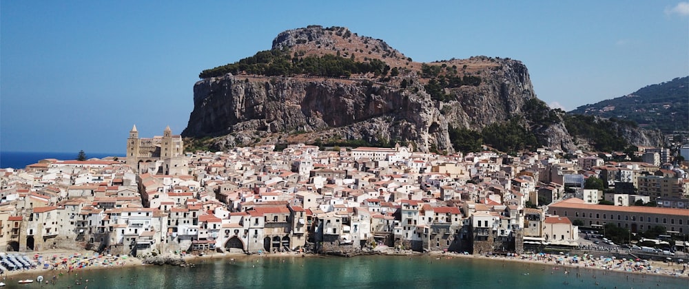 white and brown concrete houses near body of water during daytime