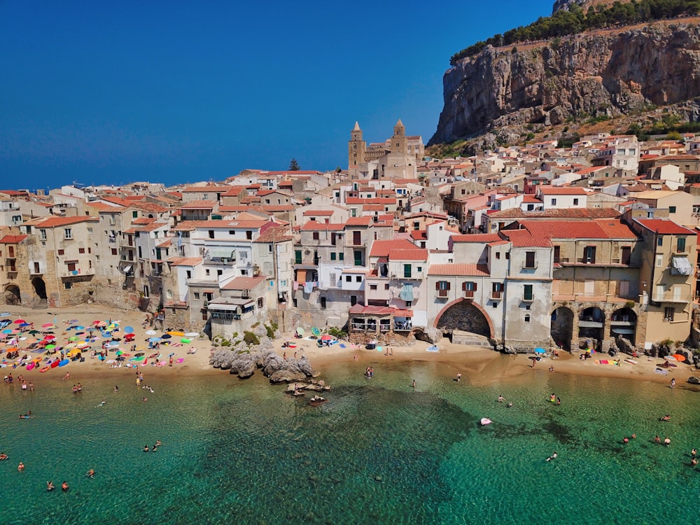 people on beach near houses during daytime