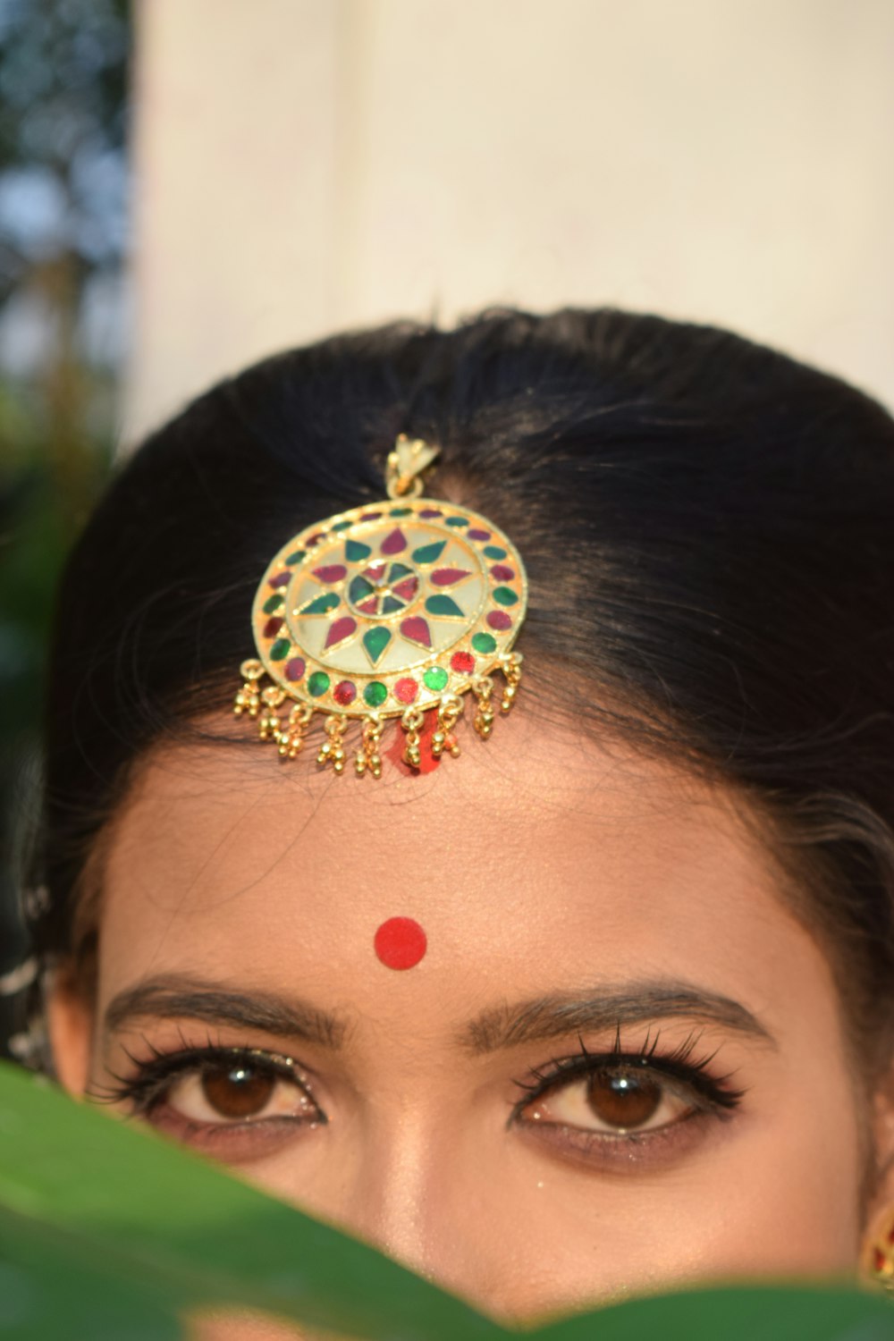 woman with gold and red flower earring