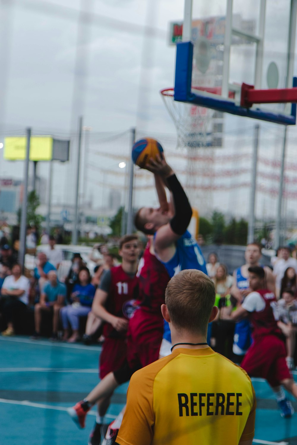 man in yellow and red jersey shirt holding orange basketball