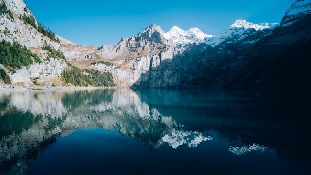 lake near snow covered mountain during daytime