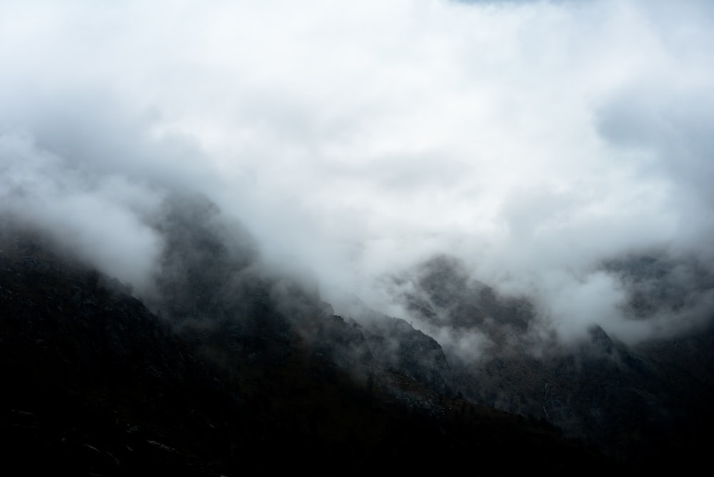 black and white mountain under white clouds