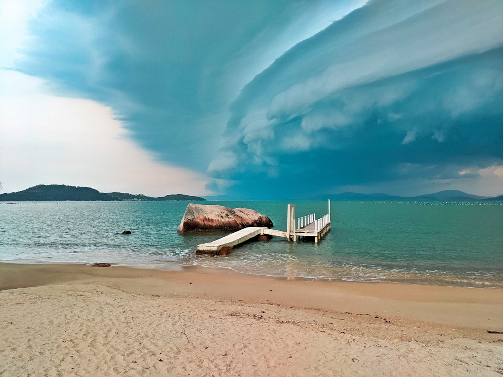 white wooden beach chair on beach shore during daytime