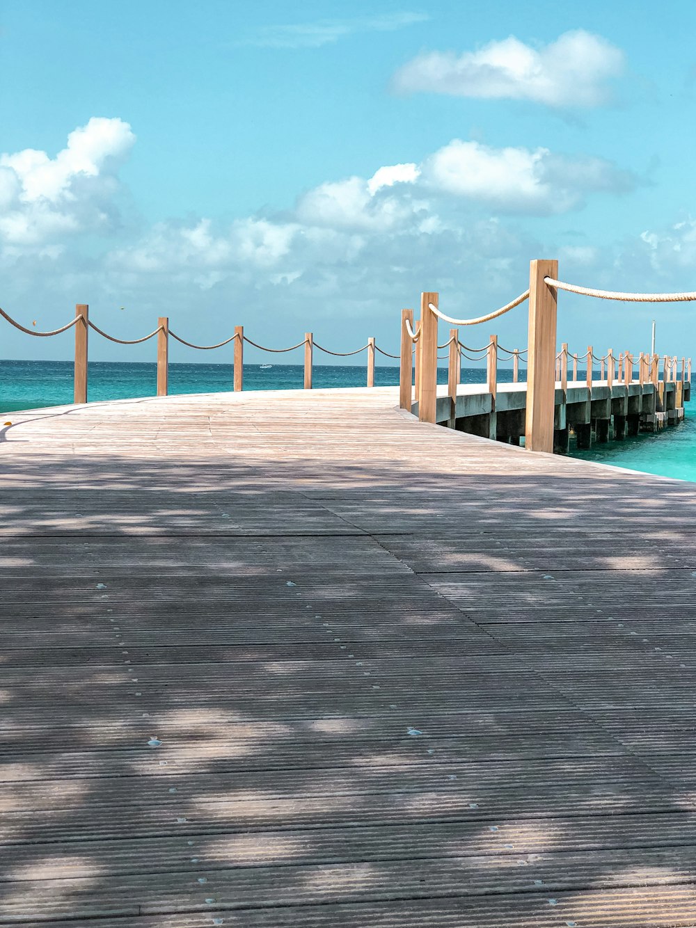 brown wooden bridge under blue sky during daytime