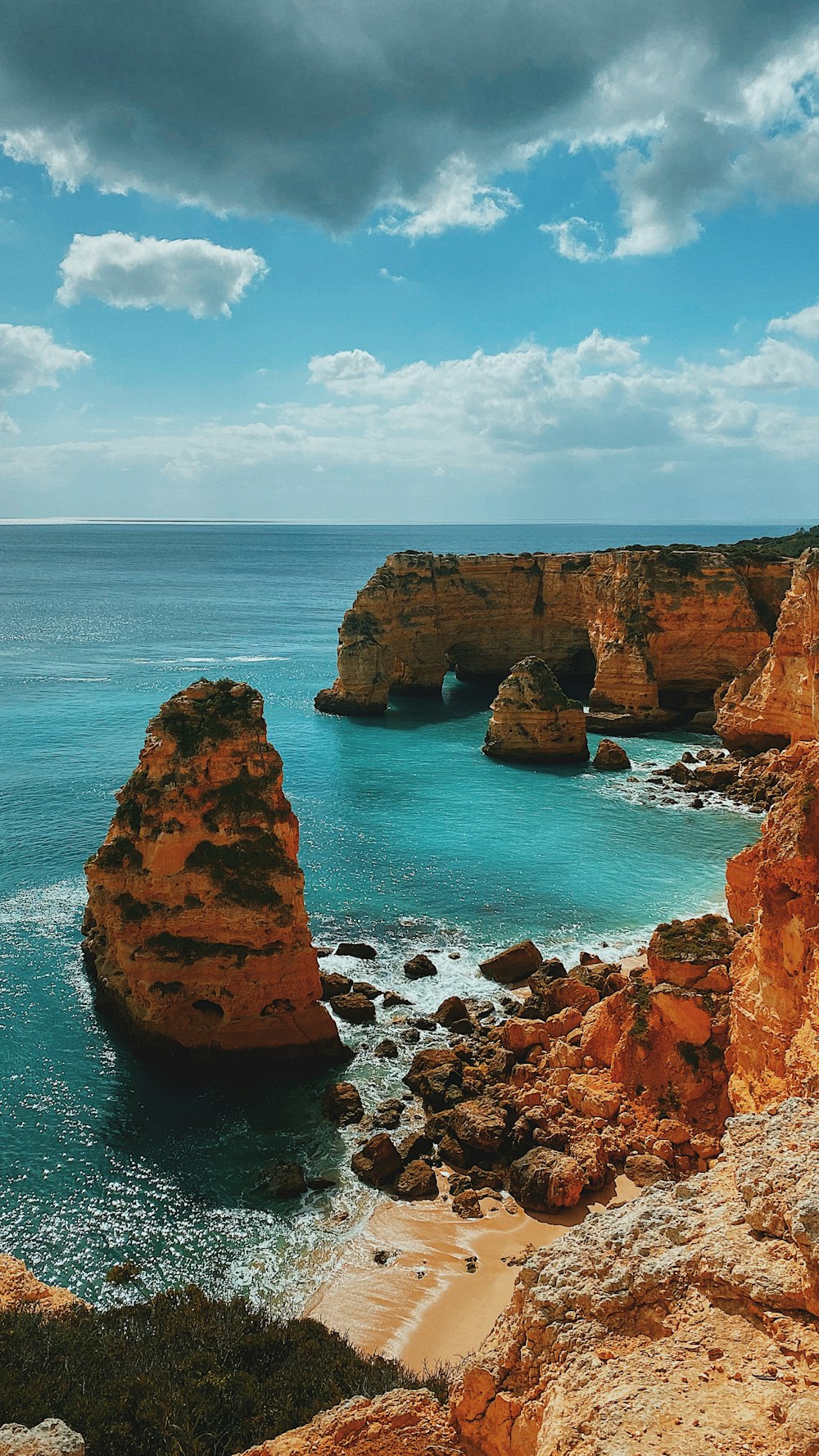 brown rock formation on sea under blue sky during daytime