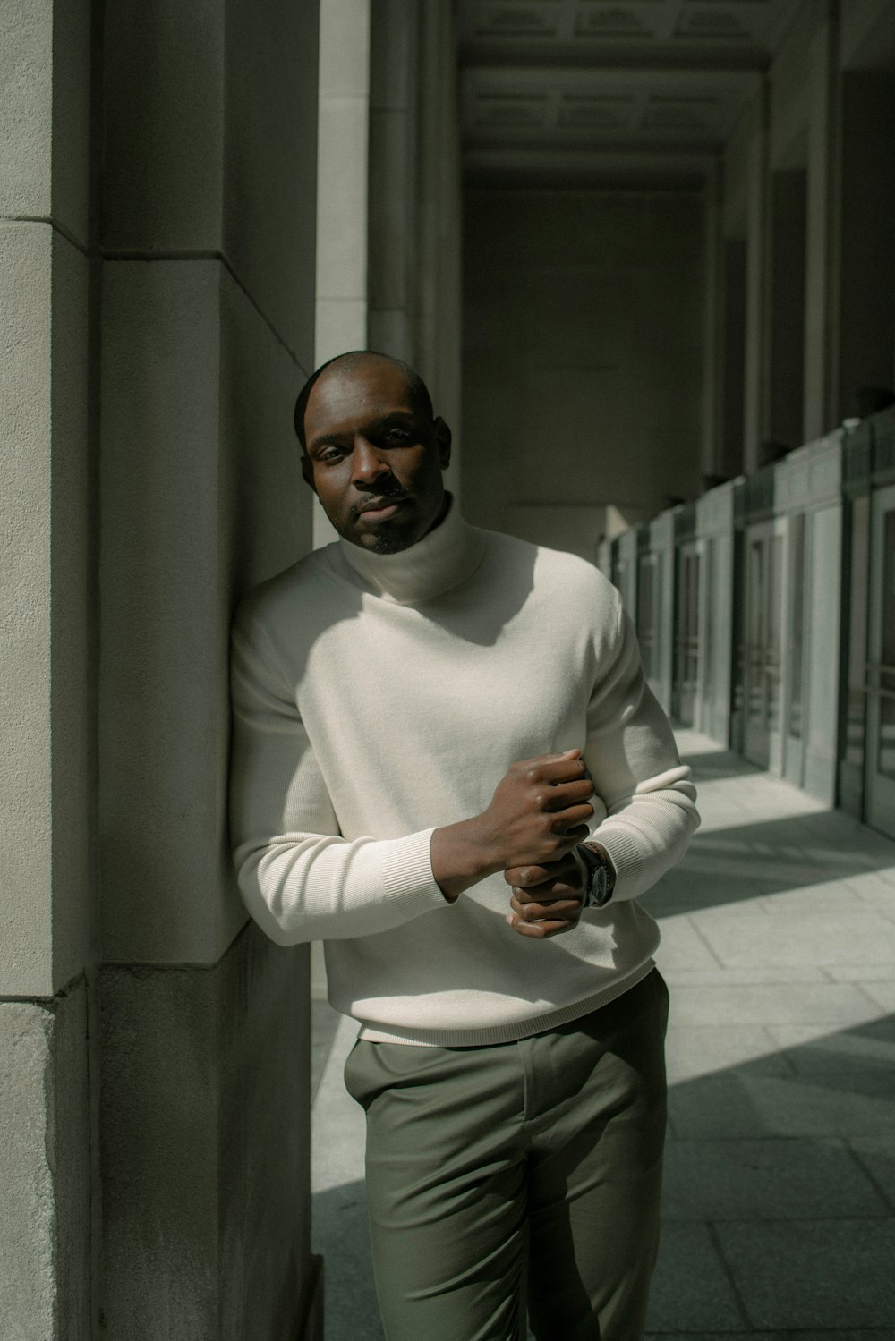 hombre en suéter blanco de cuello alto sosteniendo cámara negra