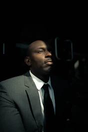 Sophisticated businessman looking thoughtfully forward with a backdrop of elegant golden light.