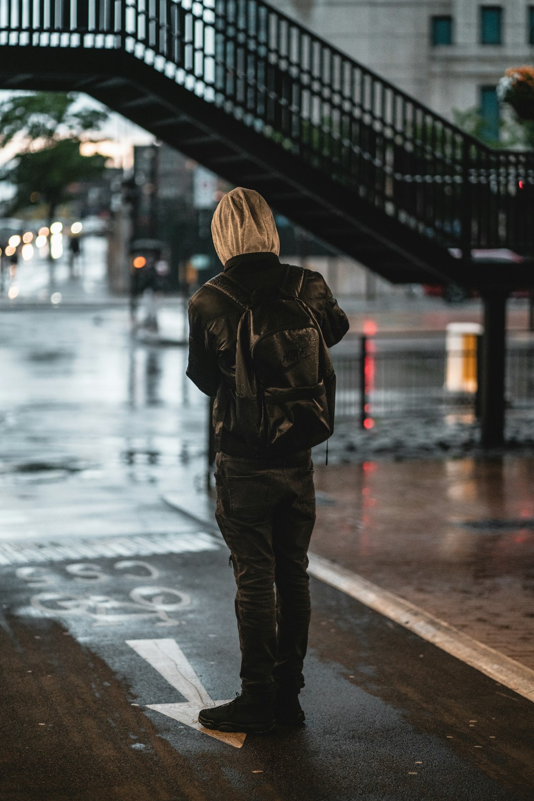 woman in brown jacket and black pants standing on road during night time
