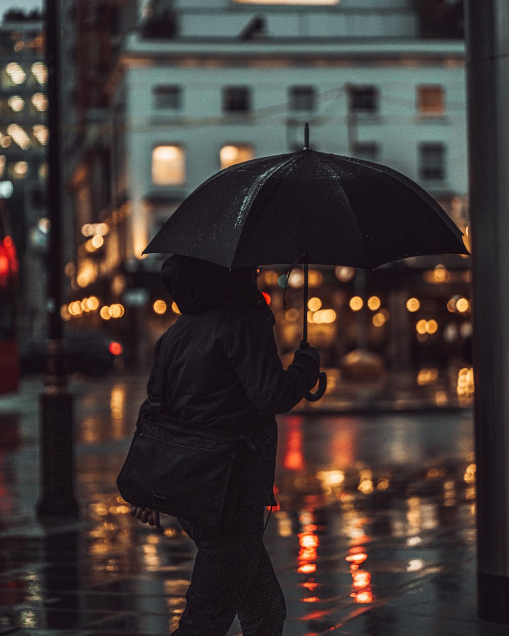person in black coat holding umbrella during night time