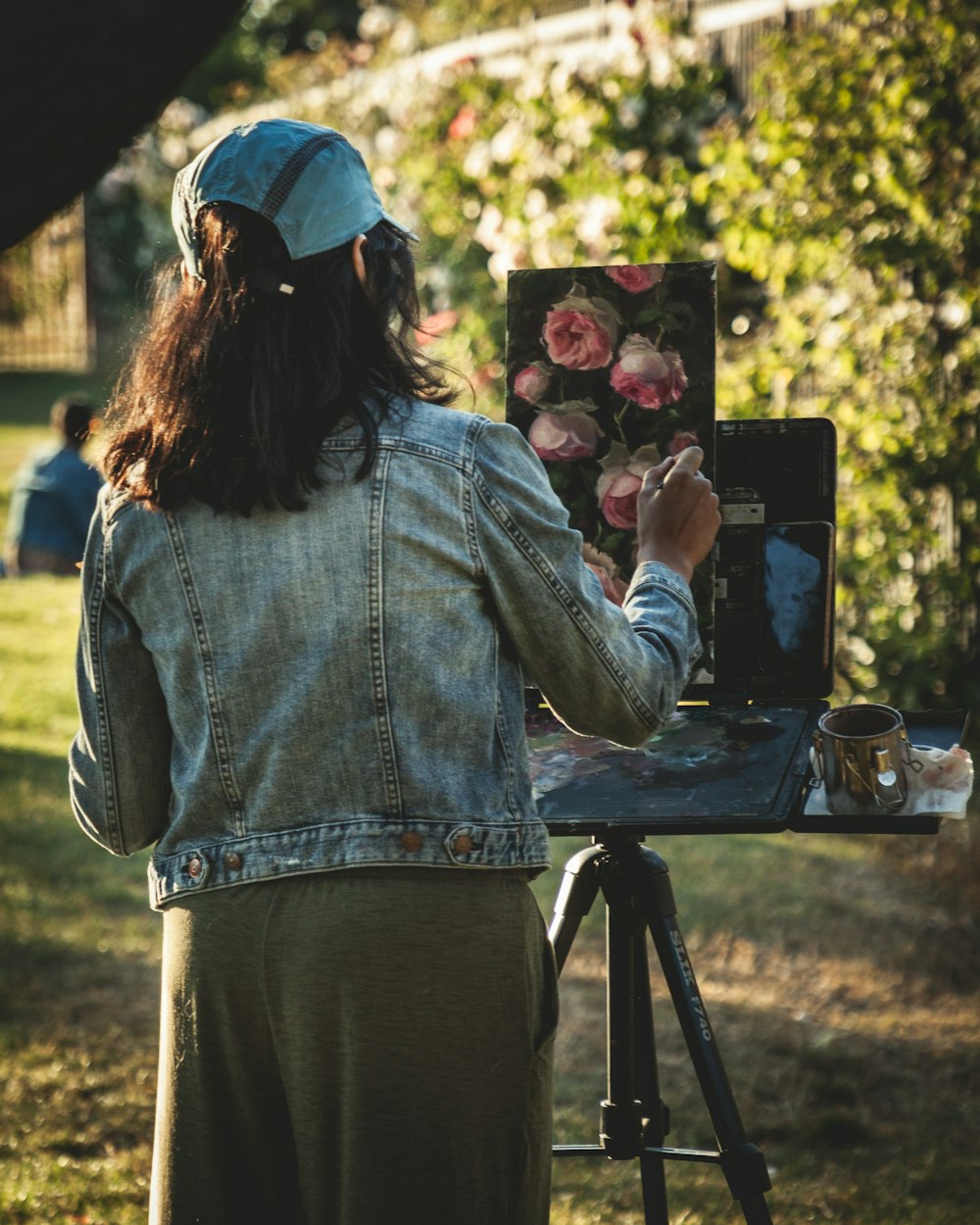 woman in blue denim jacket and blue cap holding black dslr camera