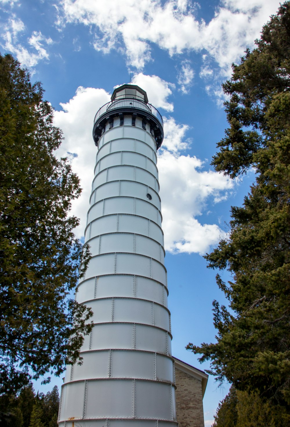 Torre de hormigón blanco cerca de árboles verdes durante el día