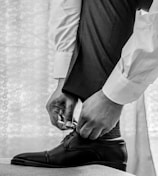 man in white dress shirt and black pants wearing black leather shoes