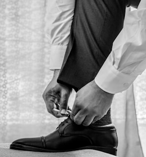 man in white dress shirt and black pants wearing black leather shoes