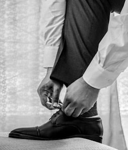 man in white dress shirt and black pants wearing black leather shoes