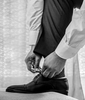 man in white dress shirt and black pants wearing black leather shoes