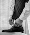 man in white dress shirt and black pants wearing black leather shoes