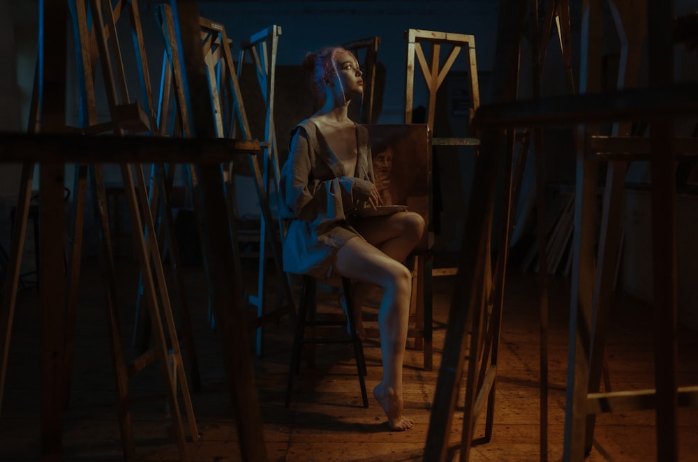 woman in white shirt sitting on blue plastic chair