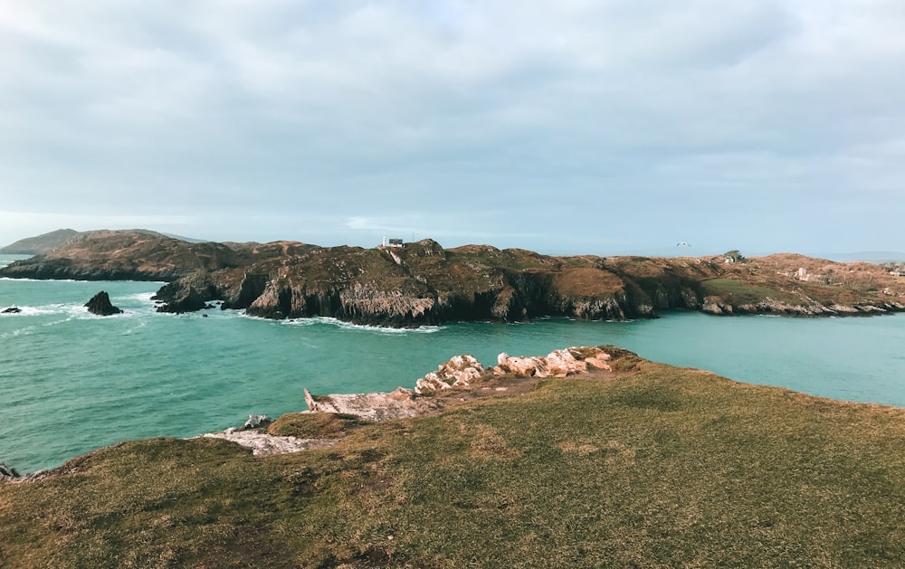 brown and white rock formation on body of water during daytime