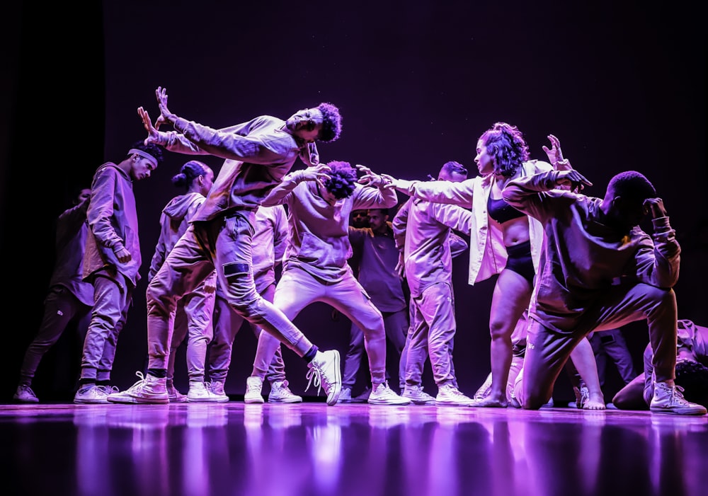 group of men in green and white shirts dancing on stage