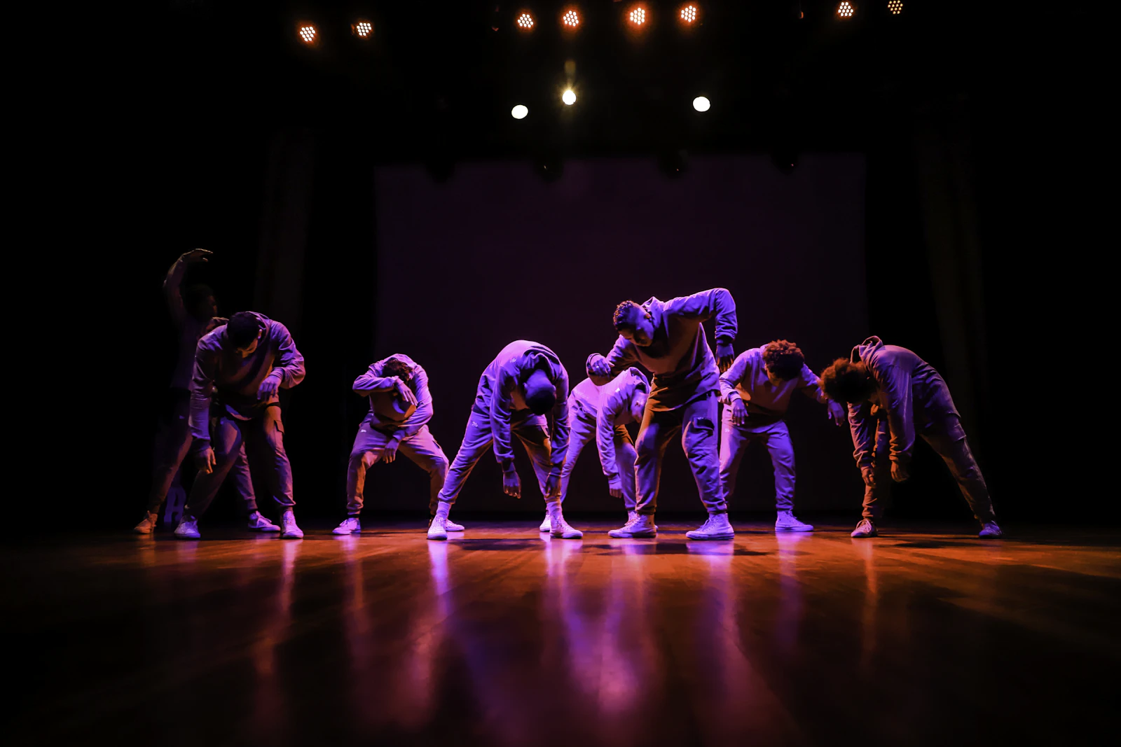 A group of dancers in greyscale mid-performance