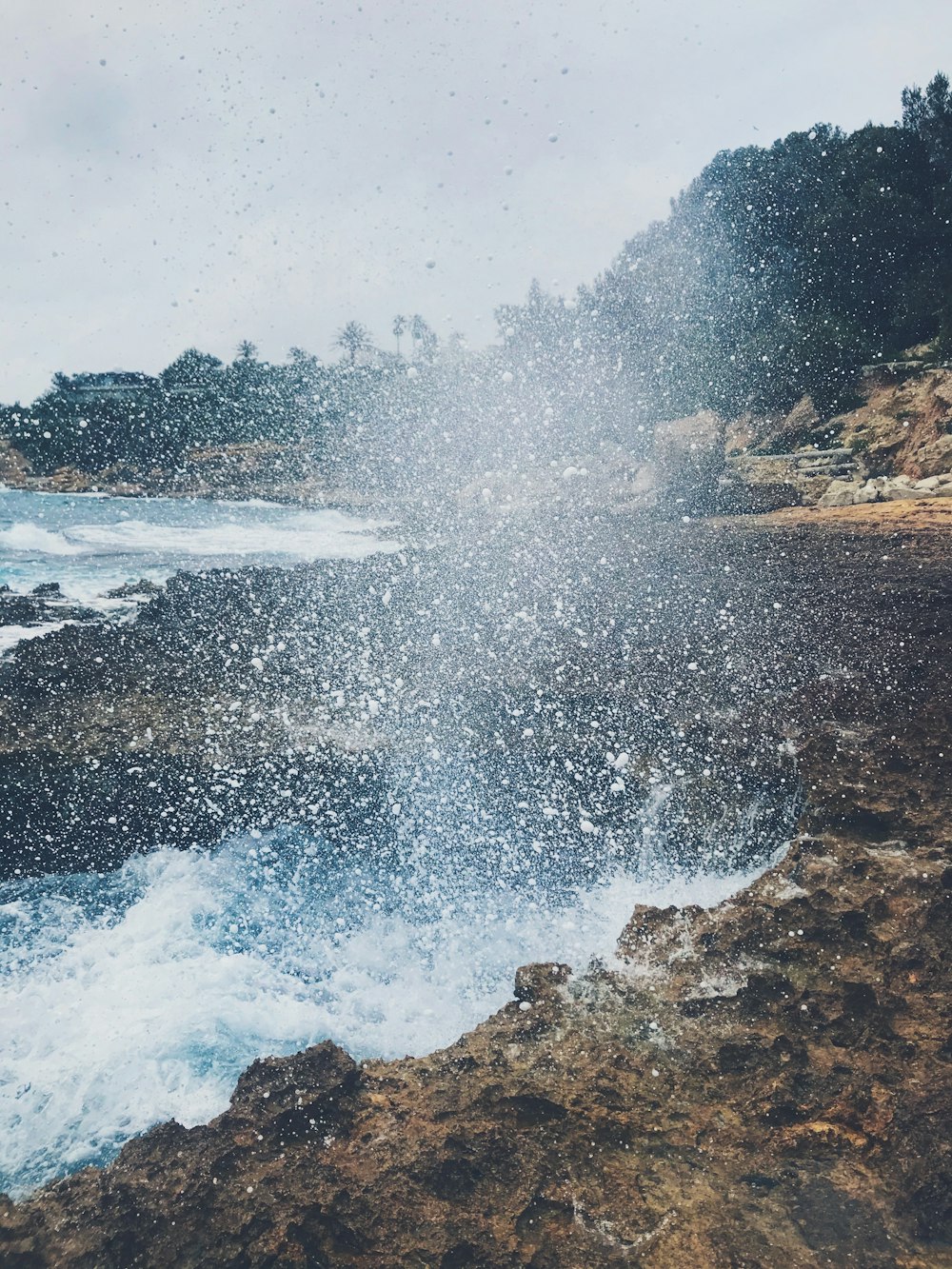 ocean waves crashing on rocky shore during daytime