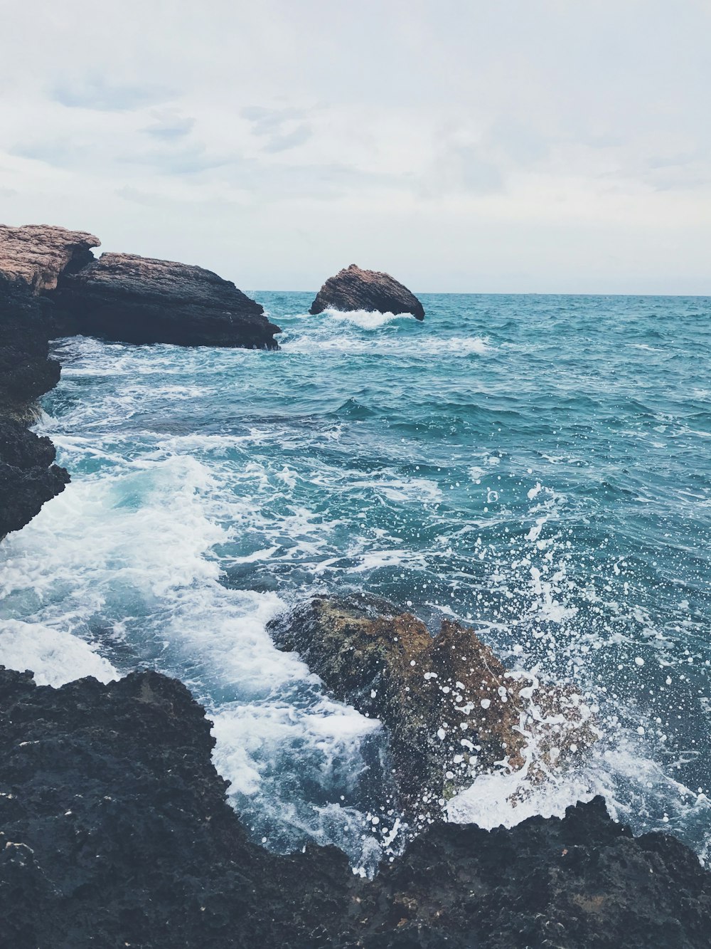 brown rock formation on sea during daytime