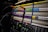 A close-up view of an audio patch panel with multiple rows of connection points. Cables with colorful ends, including orange, purple, and green, are plugged into the panel. Labels and numbers are visible above the connection points.
