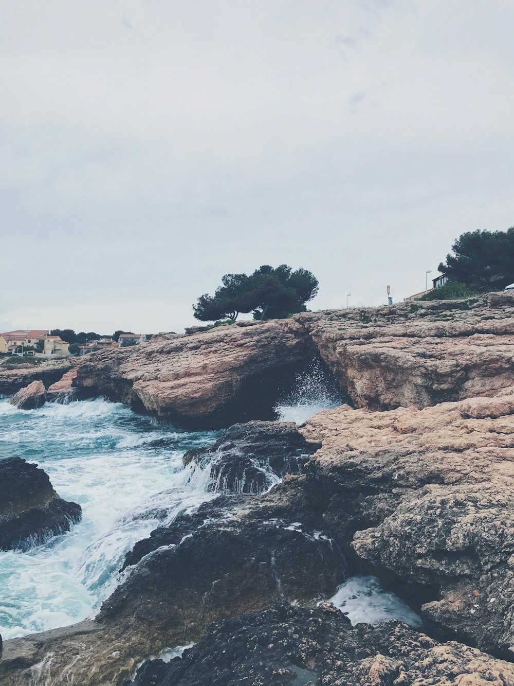 brown rock formation on body of water during daytime