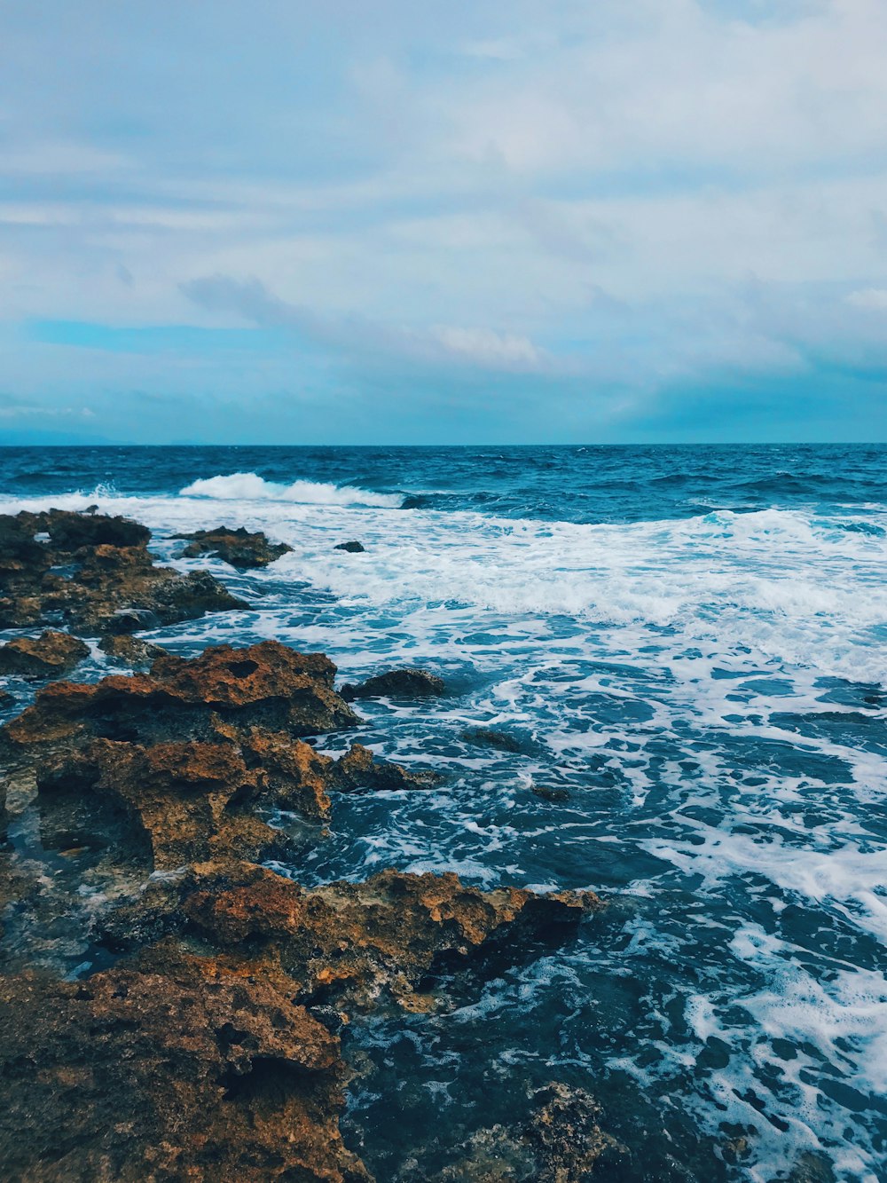 rocky shore under blue sky during daytime