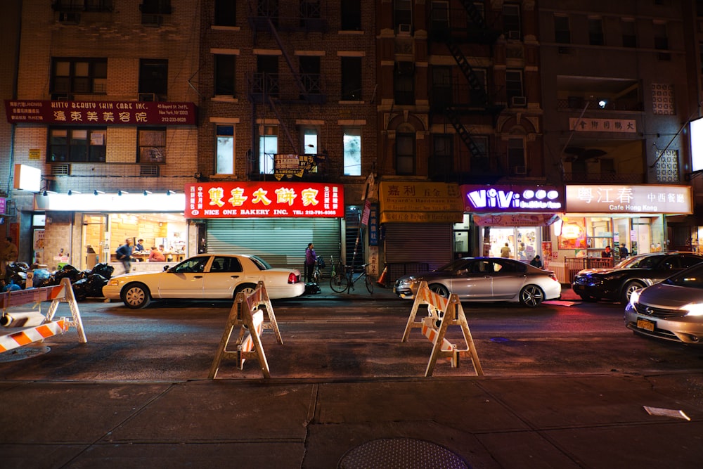 cars parked in front of brown building during night time