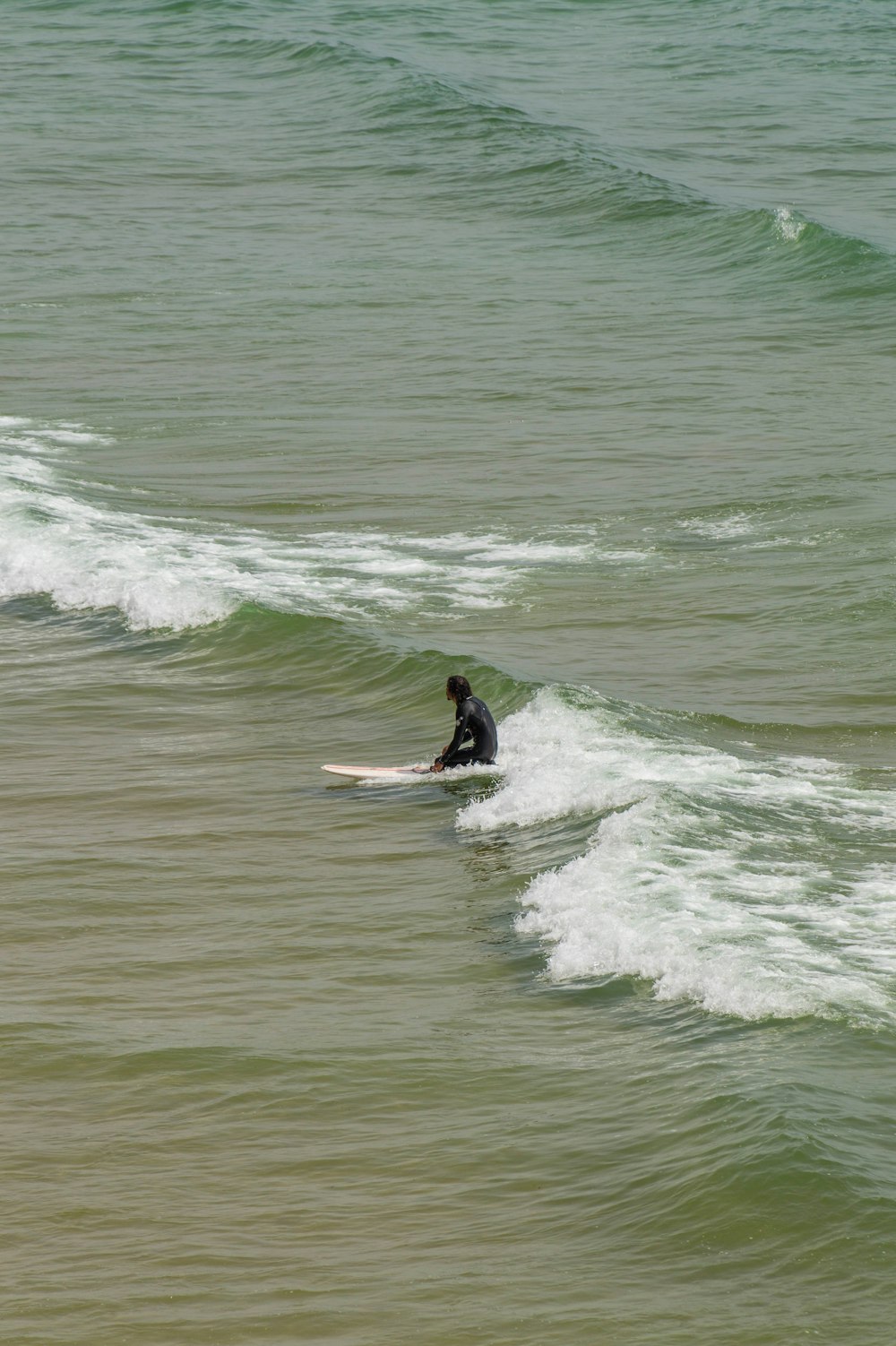 man surfing on sea waves during daytime