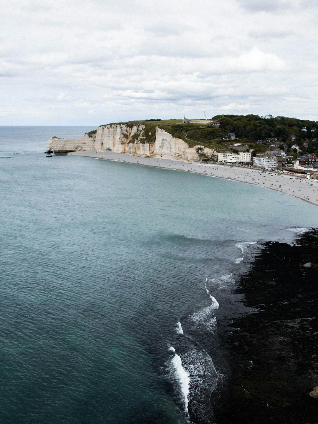 people on beach near cliff during daytime