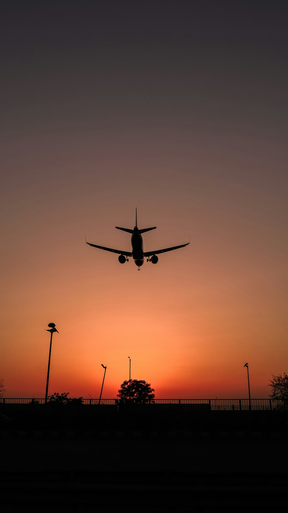 Silhouette des Flugzeugs, das bei Sonnenuntergang fliegt