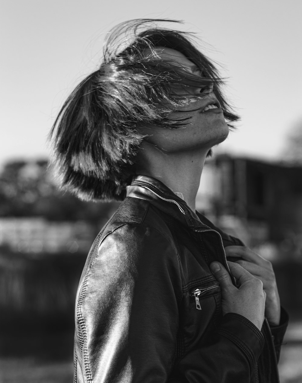 Foto en escala de grises de mujer con chaqueta de cuero negra