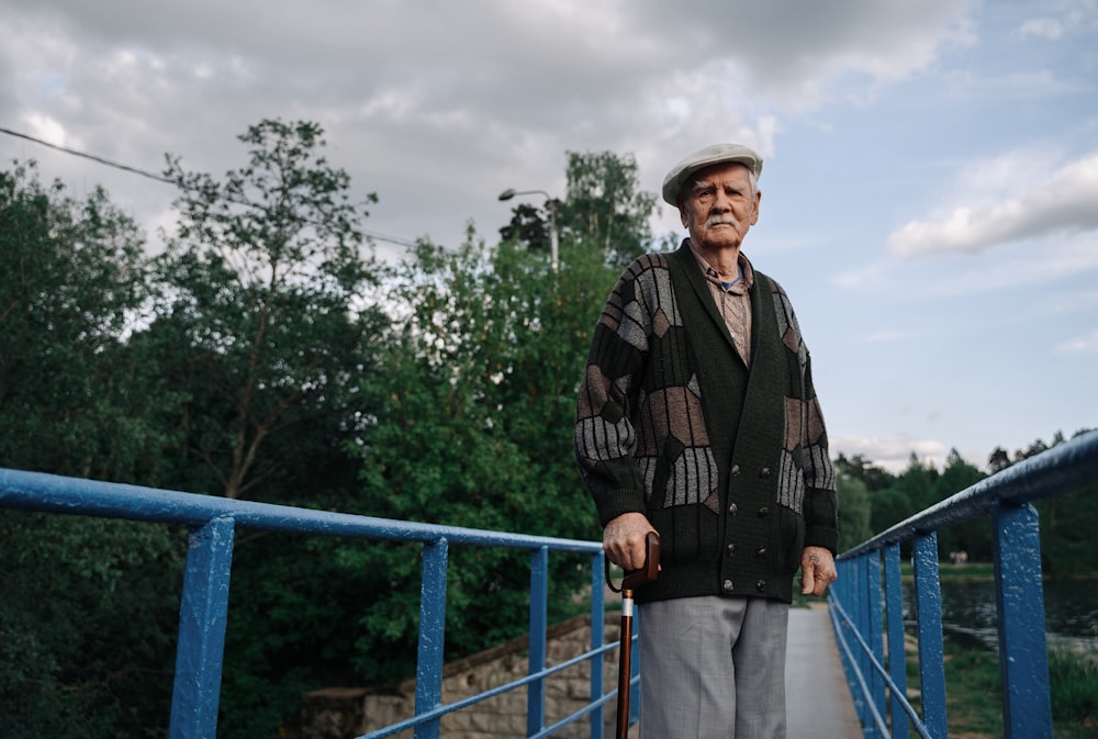 man in black and brown plaid dress shirt standing beside blue railings