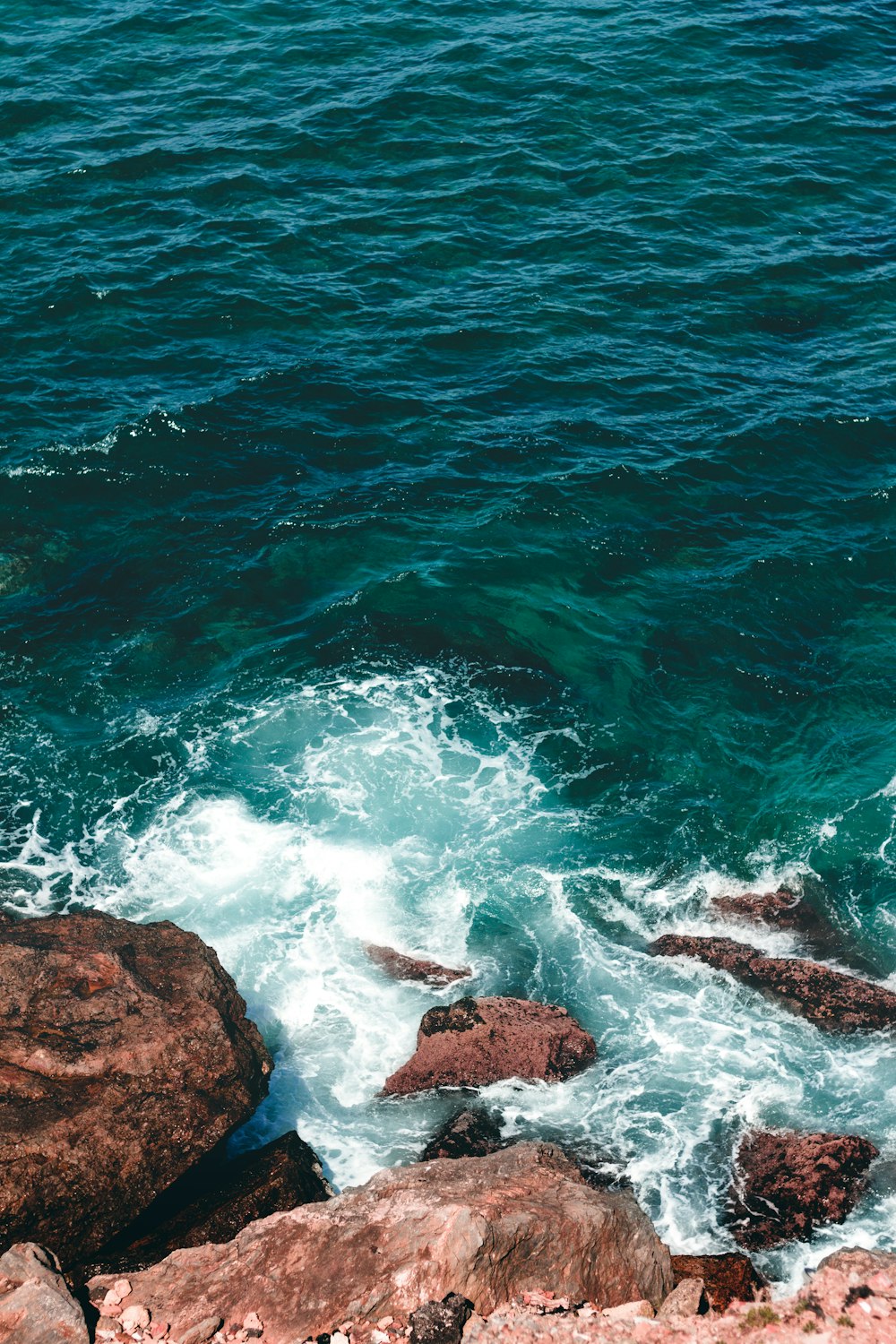 brown rock formation beside body of water during daytime