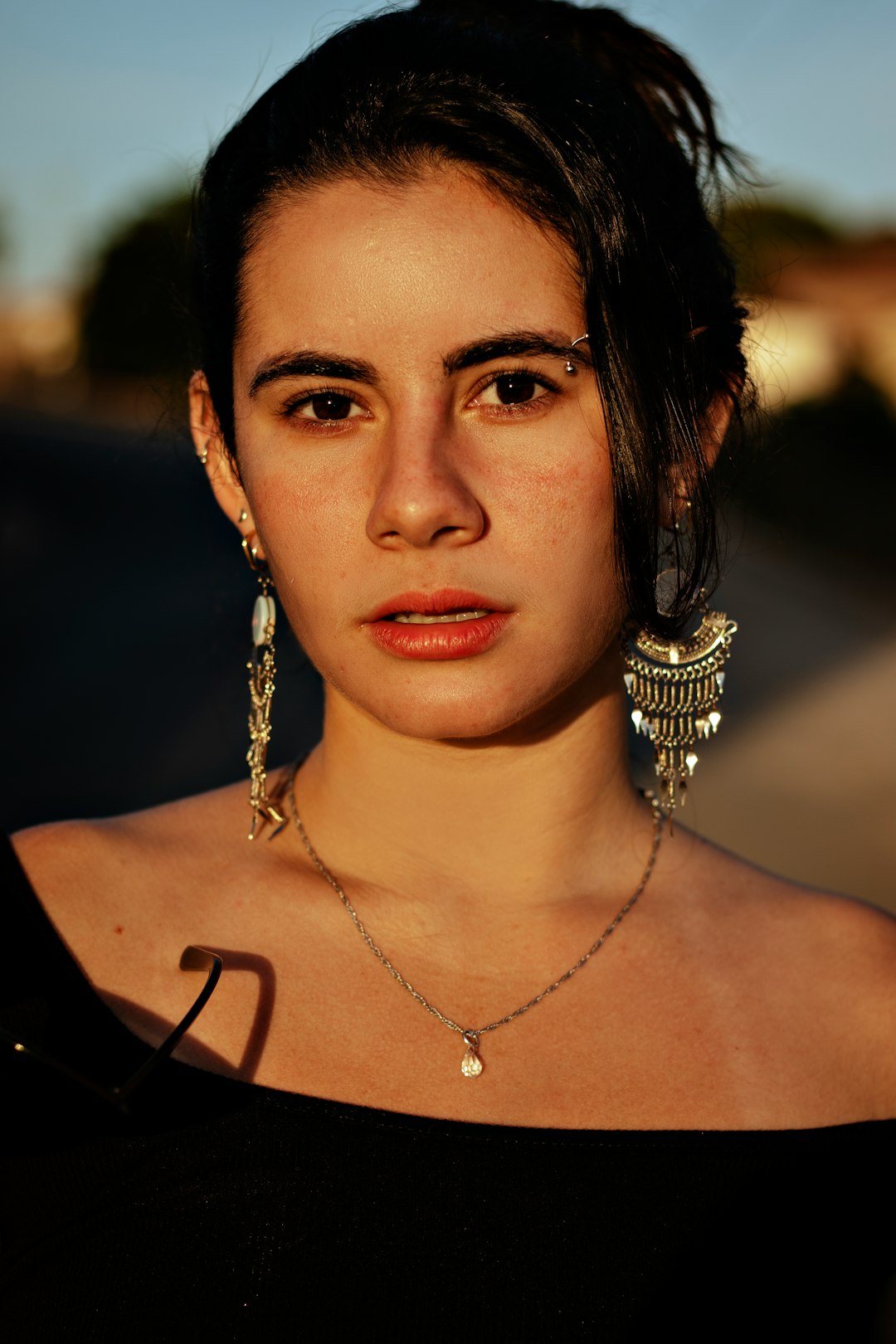 woman wearing silver necklace and silver earrings