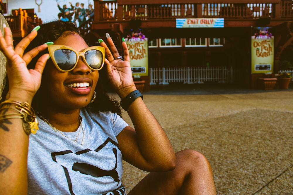 smiling woman in gray crew neck t-shirt wearing brown sunglasses