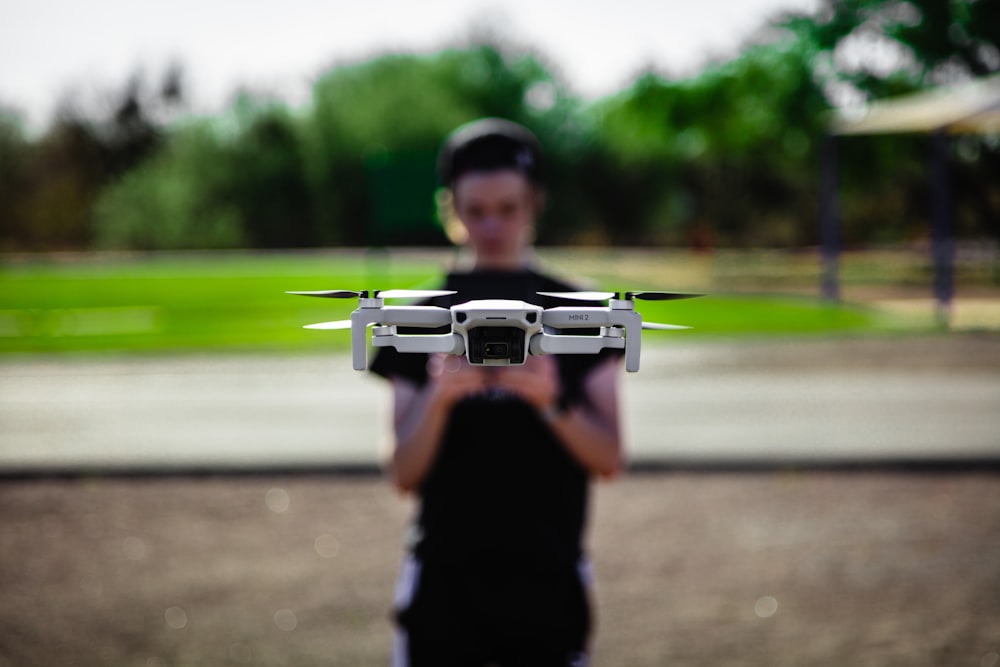 man in black shirt holding black and green drone