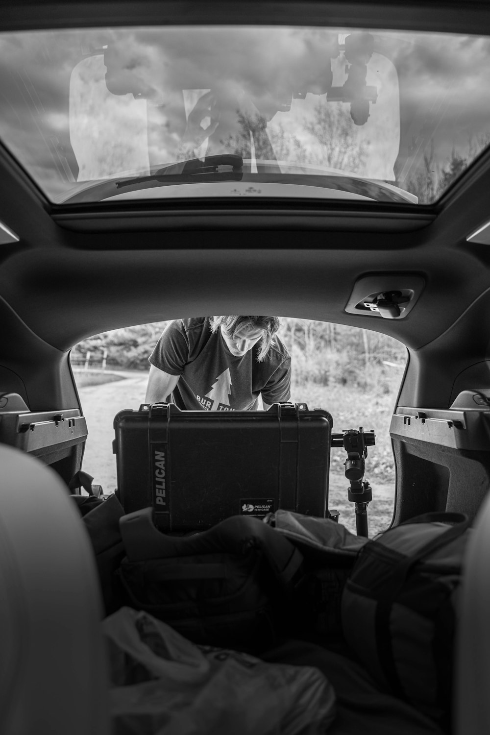 Foto en escala de grises de una persona sentada en el asiento del automóvil