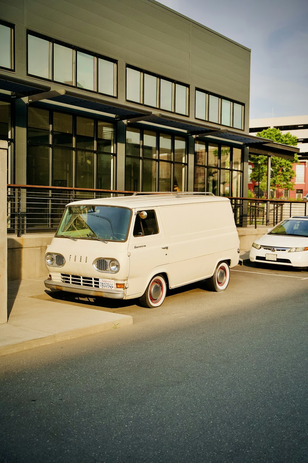 white van parked beside building during daytime